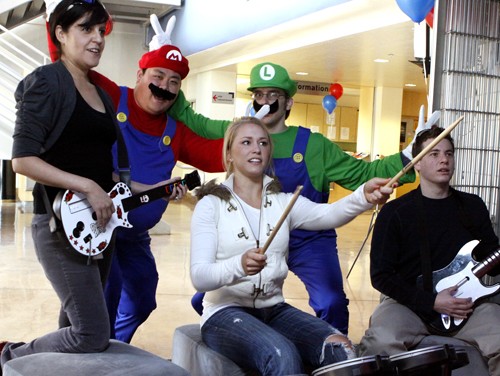 Front left to right Claudia Davila, ASUA senior coordinator, Adam Levin-Epstein, a CSIL employee and UA alumnus, and Stephanie Csongor, a pre-business sophomore, try out Rock Band on the Nintendo Wii with ?Mario? Ken Peng, biochemistry and molecular biophysics senior and ?Luigi? Cameron Davis, a UA alumnus, during the opening of CODE, the new Park Student Union gaming center, on Monday, Feb. 15.