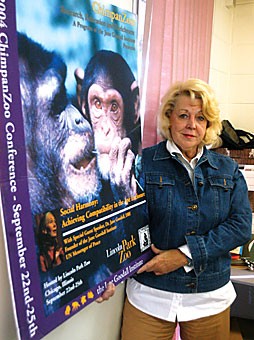 ChimpanZoo director Virginia Landau holds up a promotional poster for her program. Chimpanzoo members gather and collect data to help improve the lives of chimpanzees living in zoos.