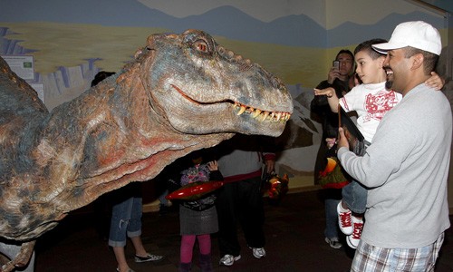 Ernie Somoza/ Arizona Daily Wildcat

Tucson resident Jose Hernandez, 37, holds up his son Adrian to pet a life-size baby Tyrannosaurus Rex, a $250,000 suit operated by two people, at Tucson Childrens Museum Thursday afternoon to get a sneak peak at  the Walking With Dinosaurs exhibit. The same dinosaur will visit Main Gate Square tomorrow from 10AM to noon.