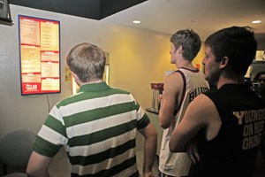 Psychology freshman Julian Seidman and business freshmen Will Vernon and Alex Pappas contemplate their dinner as they gaze at the glowing menu in the Cellar Restaurant and Lounge, in the Student Union Memorial Center. The menu for the restaurant will change for the fall, with more changes to Wilburs Underground depending on results from an online survey.