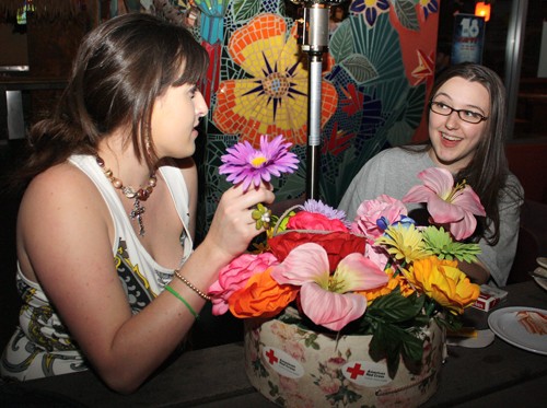 Ernie Somoza/ Arizona Daily Wildcat

From left, Tucson resident Dona Frost, 27, sells flower pens to Tucson resident Michelle Figler, 26, to raise money for the American Red Cross Haiti relief efforts last night at Gentle Bens Feb 4, 2010