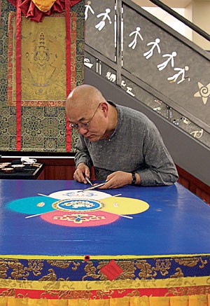 Buddhist monk, Losang Samten, creates his mandala of compassion in the UofA Bookstore using only sand and metal funnels called chakpos. He will continue working on the mandala for the rest of the week.