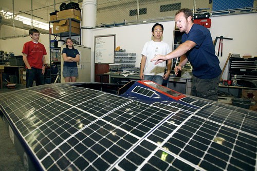 Electrical engineering senior Wei-Ren Ng, second to right, and material sciences junior Oliver Sgickroth, right, work on a solar car in preparation for an annual design competition. Their team is holding an informational meeting Saturday at noon in the Aerospace and Mechanical Engineering building, Room 221, for those interested in driving the UAs car during competition.