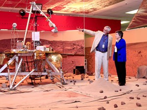 Peter Smith, senior research scientist at the Lunar and Planetary Laboratory and principal investigator for the Phoenix Mars Mission, shows off a scale-model of the Mars Lander to Arizona Gov. Janet Napolitano in the Phoenix Mars Mission Science Operation Center Feb. 13.