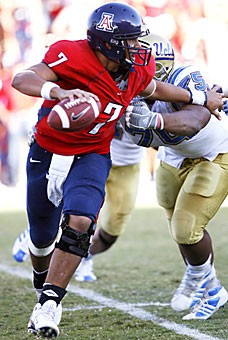 UA quarterback Willie Tuitama evades the rush of UCLA defensive tackle Kevin Brown in the Wildcats 34-27 win over the Bruins on Saturday at Arizona Stadium.