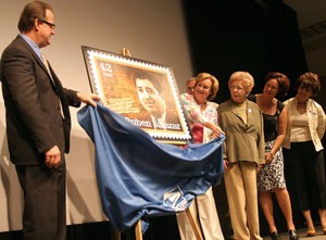 Postmaster Carl Grigle, left, helps Lisa Salazar Johnson and her family unveil the post stamp of Ruben Salazar yesterday afternoon in the Gallager Theater. Salazar was a journalist killed by tear gas fired by Los Angeles sheriffs Aug. 29, 1970, while covering the National Chicano Moratorium March, which protested Latino deaths in Vietnam.