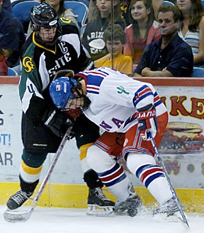 Arizona defender Zack Stommen fights for the puck with Colorado State defender Jordan Stover Saturday at Tucson Convention Center. The Icecats split their home-opening series with the Rams.