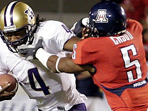 Washington quarterback Isaiah Stanback, left, stiff-arms UA junior cornerback Antoine Cason as he tries to make a tackle in Arizonas 21-10 loss to the Huskies Sept. 30. Cason, whos fourth on the team in tackles, will also use his hands to hold kicks. Cason practiced holding this week and will be the teams back-up holder Saturday at Stanford.