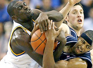 Arizona guard Mustafa Shakur, right, and UCLA forward Alfred Aboya, left, fight for a rebound as UA forward Ivan Radenovic reaches from behind during the first half of No. 11 Arizonas 73-69 loss at No. 3 UCLA Saturday in Pauley Pavilion in Los Angeles. Shakur had 12 points and handed out eight assists.