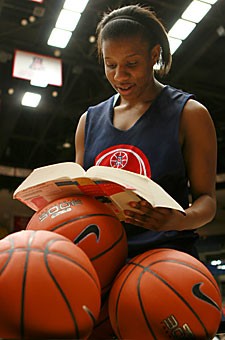 UA womens basketball player Joy Hollingsworth poses with her book at practice Feb. 6 in McKale Center. Like all UA athletes, Hollingsworth must juggle a schedule that includes academics and athletics.