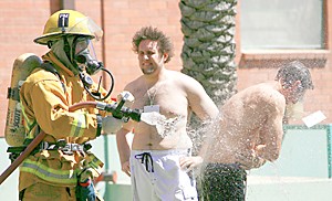 A paramedic with the Tucson Fire Department hoses off one of the simulated victims in yesterdays emergency response drill held near Coconino Hall. Various agencies from around the county took part in the yearly exercise. (photo by chris coduto/arizona daily wildcat)