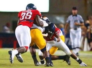 UA linebacker Sterling Lewis, 35, teams up with cornerback Marquis Hundley, 23, to take down the ball carrier in a 41-16 win over Toledo Saturday at Arizona Stadium. Lewis had a team-high 12 sacks in the game in relief for an injured Xavier Kelley. 