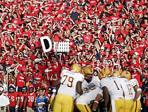 Zona Zoo cardholders in the student section cheer on the Wildcat football team in last seasons 28-14 loss to ASU at Arizona Stadium Nov. 25. After nine bowl-less years, the Arizona football program looks to make to redeem itself.