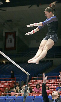 Junior gymnast Aubrey Taylor releases the uneven bars during her one-touch warm-up before the competition against Denver, Southeast Missouri and Cal-State Fullerton March 10 in McKale Center. The Gymcats have already started training for next year.