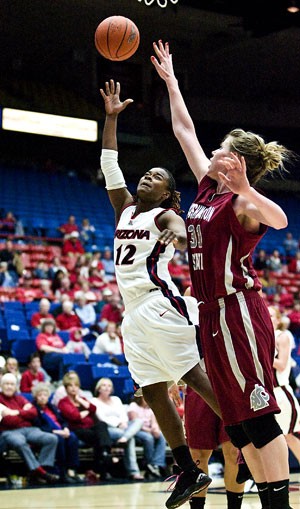 Arizona guard Ashley Whisonant tosses the ball over Washington State forward Heather Molzen in a 67-54 loss on Feb. 23 in McKale Center. Whisonant has been a vital cog for the UA womens basketball team this year.