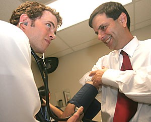 Scott Cheney, a second-year medical student, stops to check Phoenix Mayor Phil Gordons blood pressure during Gordons tour of the UA College of Medicine yesterday afternoon. Gordon has been a strong supporter of the College of Medicines expansion to the Phoenix Biomedical School.