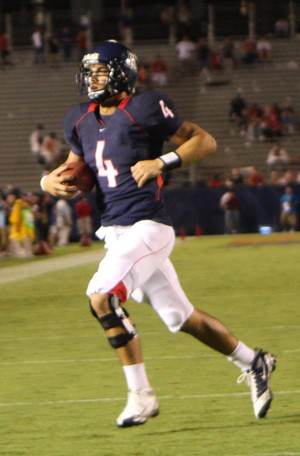 UA backup quarterback Matt Scott runs with the football during a warmup earlier this season. Scott was the only one of his three good friends to choose Arizona over ASU as freshmen. Scott hopes to contribute in Saturdays game against ASU at Arizona Stadium at 6 p.m. 