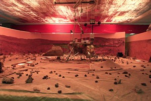 A replica of the Phoenix Mars Lander sits in an environment set up to look like Mars at the Phoenix Mars Mission Science Operations Center.