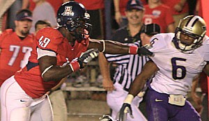 Earl Mitchell grabs a handful of cornerback Matt Fountaines jersey during Arizonas 21-10 loss to Washington on Saturday at Arizona Stadium. Mitchell, who plays full back, H-back, tight end and on special teams, is the Wildcats only true freshman starter and had one catch for 27 yards against the Huskies.