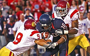 Arizonas Mike Thomas is swarmed by USCs Cary Harris (7) and Mozique McCurtis (9) in the second quarter of Arizonas 20-3 loss to the Trojans Saturday at Arizona Stadium. Thomas had a season-high seven catches for 78 yards, but fumbled a crucial punt late in the fourth quarter.