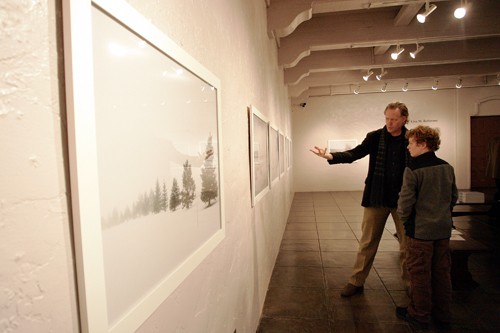 Mike Christy / Arizona Daily Wildcat

Herb Stratford, pointing at right, and 13-year-old Matthew Satori, discuss a photograph last Friday from Lisa M. Robinsons Snowbound photography series on display at the Temple Gallery on South Scott Avenue in downtown. The series will be available for viewing until February 23.