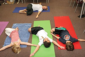 Yoga instructor Sharon Discorfano (top) teaches eight-year-olds (from left to right) Eleanor Allen Henderson, Donavan Miller and Kaelan Rae a yoga position. The Continuing Education and Academic Outreach are holding a series of summer camps for elementary, middle school and high school students.