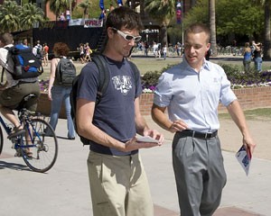 ASUA Sen. Mark Copoulos, right, talks to Dakota Scibilia, a computer sciences sophomore, about the ways to pay less for textbooks that the UA already has in place, Wednesday afternoon on the UA Mall.