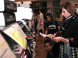 Architecture senior Sarah Ingham shuffles through the books at the Student Union Memorial Center for her general education classes yesterday afternoon. Students have been buying books and supplies for the oncoming semester.