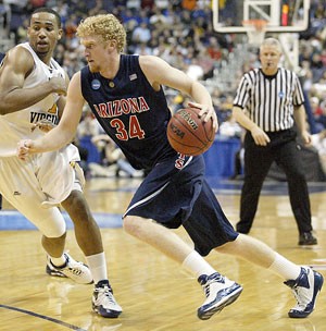 UA forward Chase Budinger drives by West Virginia forward DaSean Butler in a 75-65 Mountaineer win in Washington, D.C., Thursday night. Budinger said hell take roughly a week off before deciding if hell go pro next season.