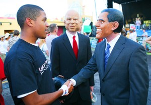 James Brooks, left, an entreneurship freshman, shakes hands with the pseudo-presidential candidates, Dan Fitzgibbon, right, a pre-business freshman, and Kyle Beard, center, a computer science freshman, at the UAVotes block party put on by the ASUA along University Blvd. Friday night.