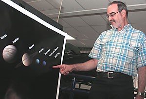 Larry Lebofsky points to one of the three proposed new planets that would have been added to our solar system under a proposal given to the International Astronomical Union. The IAU voted yesterday that Pluto and the three proposed objects are not actually planets.