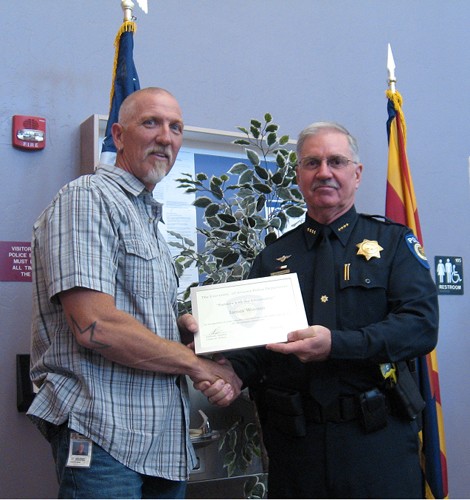 James Wooten, lead plumber in the UA facilities management department, receives an award certificate from Chief Anthony Daykin at University of Arizona Police Department main station on Wednesday, Oct 3. Wooten and other community members were honored for helping the UAPD crack crimes and catch criminals.