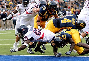 Arizona running back Nick Grigsby squeezes through members of the California defensive line to reach the end zone during the Wildcats loss to the Golden Bears on Saturday in Los Angeles. Grigsby accounted for the only touchdown of the first half and the first of the game. 