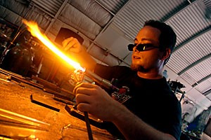 Nick Amparan adds color to his latest glass creation by heating the tip of a color rod. Amparan has known the Dark Alley glassblowers for more than four years.