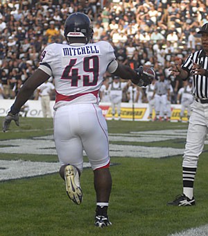 Arizona fullback Earl Mitchell hands the ball over to the referee after his 7-yard reception for a touchdown during the Wildcats 20-7 loss to Brigham Young on Saturday. Even though the fullback position is not looked upon as necessary in a spread offense, head coach Mike Stoops said Mitchell will get plenty of touches. 