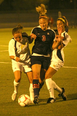 Arizona midfielder Samantha Drees wedges between two Michigan players in a 1-0 overtime win Friday at Murphey Stadium. Karina Camacho scored the goal to win it for the Wildcats.
