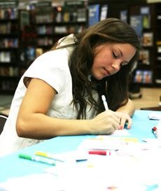 Lara Gruden, a psychology freshman and member of Pi Beta Phi sorority, draws a picture on to a bookplate during the Make Your Mark For Literacy campaign held at Barnes & Noble bookstore off of Broadway Blvd. on Saturday afternoon. The bookplates will be used as vouchers for new books to be donated by First Book Foundation to children.  