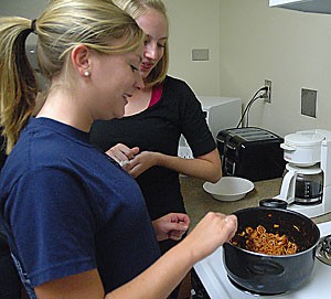 Sociology freshman Melissa Nicholson cooks pasta with pre-nursing freshman Megan Befort in the Arizona-Sonora Residence Hall last night.