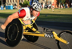 Eric Hightower, a member of the Arizona Heat Racing Team, rolls through the finish line, taking first place in the Elite Wheelchair race of Jim Clicks Run N Roll event yesterday morning. 