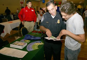 Matthew Marcoccia, left, a national recruiter for U.S. Customs and Border Protection, speaks with Daniel Teran, a general biology junior, about the Border Patrol service Thursday evening at the Career Fair held in the North Ballroom of the Student Union Memorial Center. 