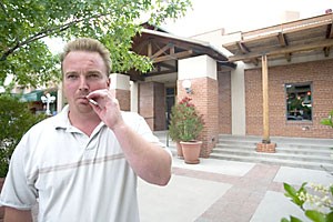 Wayne Johnson steps out of Gentle Bens yesterday to have a smoke. Johnson said he believes the smoking ban, which went into effect yesterday, is a pain in the ass. 