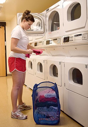 Elise Ramirez, an undeclared freshman and resident of Villa Del Puente Residence Hall, folds laundry in her dorms laundry room yesterday evening. Dorm rates will see an 8.9 percent increase starting next year, most of which will be used to build more residence halls.