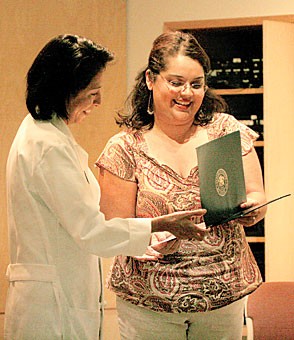 Dr. Ana Maria Lopez, an associate professor of clinical medicine and pathology, accepted her award from Doralina Skidmore, right, administrative assistant to congressman Raul M. Grijalva, yesterday at the Local Legends Assembly, held at the University Medical Center. Grijalva, who nominated Lopez for the award, hailed her as one of Americas best doctors.