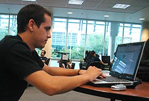 Pre-business freshman Oscar London connects with his laptop to the universitys wireless network in the Manuel T. Pacheco Integrated Learning Center yesterday. The Office of Student Computing Resources is implementing new security measures that requires students to have certain security software installed on their computers.