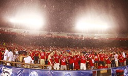 At top and bottom, hordes of the Zona Zoo faithful remained steadfast in the stands of Arizona Stadium on Saturday amid lightning, thunder and torrential rain. Middle, Dominic Gaiser, an undeclared freshman, is tackled and taken away during the weather delay at the Arizona-Idaho blowout Saturday night. Gaiser attempted to rush the field, but was quickly apprehended by law enforcement officials. 