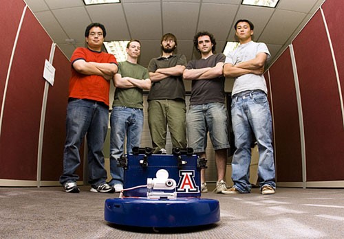 From left, electrical engineering senior Tony Leung, computer engineering senior Joe Joyce, computer engineering senior John Stockbauer, electrical engineering senior Michael Anderson and computer engineering Thanh Ho stand behind the robot they built for the Arizona Intel Robot Challenge taking place tomorrow in Tempe against ASU.