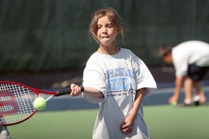Cassandra, 10, from Fort Lowell Elementary School receives tennis lessons from the UA mens and womens tennis team.