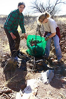 Georgia Ehlers, director of the Peace Corps Fellows at the UA, left, and Carrie Jacobson, a returned Peace Corps volunteer, clean up trash most likely left by illegal immigrants crossing the Arizona-Mexico border on Saturday. 
