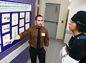 Biochemistry and molecular and cellular biology senior Douglas R. Mathern, left, has spent the past months working on ways to improve skin health, such as fighting wrinkles. Biology senior Dalziel Dominguez listens closely to Matherns explanations at the 18th annual Undergraduate Biology Research Program conference Saturday.