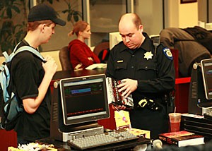 UAPD officer Mario Leon questions a student about the origin of the textbooks he was attempting to sell to the UofA Bookstore yesterday. The books matched the description of some that had been reported stolen earlier that day. Bookstore officials said that reports of stolen texts are a common occurrence once buybacks have begun.